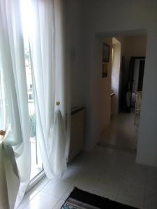 Habitación con ventana y cortinas blancas. en Casa Fontana, en Arcola