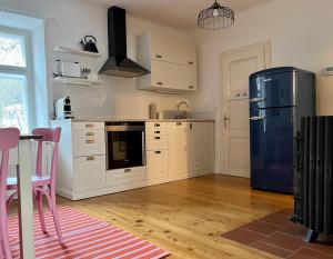 eine Küche mit einem Kühlschrank sowie einem Tisch und Stühlen in der Unterkunft Alte Backstube in Waidhofen an der Thaya