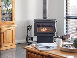 a living room with a fireplace and a table with a book at Busselton Broadwater Holiday Home in Busselton