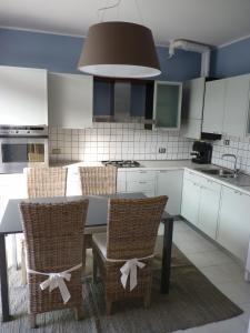 cocina con mesa y sillas de mimbre con arcos en Casa Iglesias, en Cavallino-Treporti