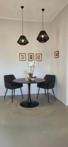 a dining room table with two chairs and two lights at Perivleptos Ι in Perdika
