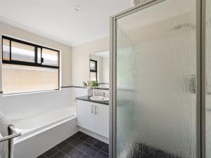 a bathroom with a shower and a tub and a sink at Busselton Broadwater Holiday Home in Busselton