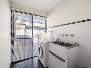 a kitchen with a washing machine and a sink at Busselton Broadwater Holiday Home in Busselton