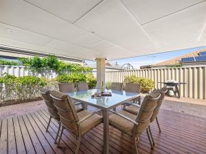 a table and chairs on a deck with a fence at Busselton Broadwater Holiday Home in Busselton