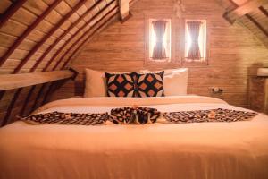 a bedroom with a large bed in a room at Wisnu Lumbung Uluwatu in Uluwatu
