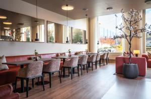 a restaurant with tables and chairs and windows at Thon Hotel Ullevaal Stadion in Oslo