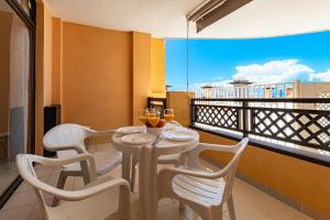 a dining room with a table and chairs on a balcony at Sunset Flower Apt By Dream Homes Tenerife in Puerto de Santiago