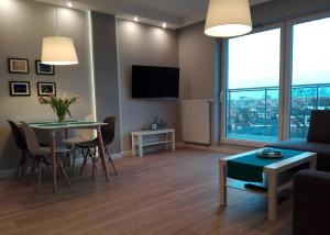 a living room with a couch and a table with chairs at Apartament Kopernik in Olsztyn