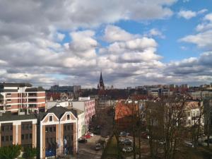 a view of a city with buildings and a cloudy sky at Apartament Kopernik in Olsztyn