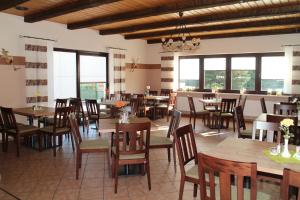 ein Restaurant mit Holztischen und -stühlen und Fenstern in der Unterkunft Hotel Zur Wildtränke in Spremberg
