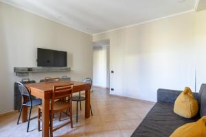 jadalnia ze stołem i krzesłami oraz telewizorem w obiekcie Crosti Apartments w Rzymie