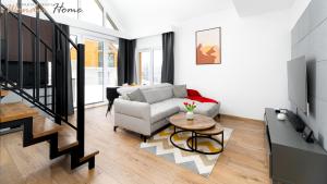 a living room with a couch and a table at Wonder Home - Domki Hillside tuż przy stoku narciarskim - na terenie kompleksu plac zabaw i zewnętrzna siłownia, sklep, parking in Karpacz