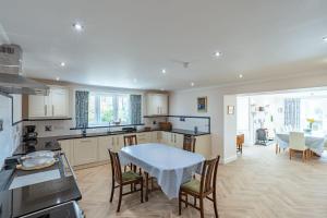 ゲートハウス・オブ・フリートにあるOrnockenoch Houseのテーブルと椅子のあるキッチンとダイニングルーム