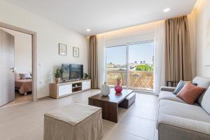 a living room with a couch and a tv at Respire modern house near sea in Gázion