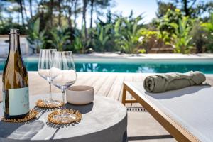 a bottle of wine and glasses on a table next to a pool at Can Toni in Sa Pobla