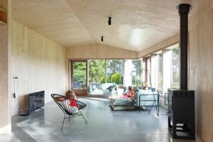 a living room with two children sitting in chairs and a fireplace at Haaghoek, design vakantiewoning in Horebeke