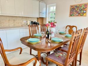 eine Küche mit einem Holztisch mit Stühlen und einem Esszimmer in der Unterkunft Swan Cottage 2-Bedroom-Netflix-Parking-Nature-Canal in Kidlington