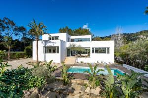 a white house with a swimming pool and trees at Can Toni in Sa Pobla