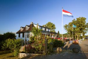 a house with a flag flying in front of it at Café Brasserie Het Heerenhuis in Het Kalf
