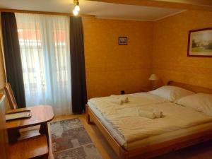 a bedroom with a bed with two towels on it at Czérna Vendégház in Tata +7 photos