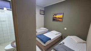 a small bathroom with two beds and a toilet at Hotel & Hostel San José in Ribeirão Preto