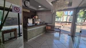 a restaurant with a counter and a clock on the wall at Hotel & Hostel San José in Ribeirão Preto