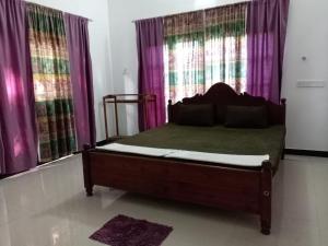 a bed in a room with purple curtains at Royal Hotel in Mihintale