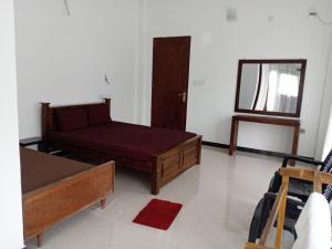 a living room with a bed and a mirror at Royal Hotel in Mihintale +6 photos