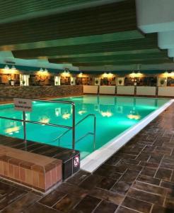 a large swimming pool with blue water in a building at Panorama Apartment in Bad Harzburg