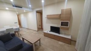 a living room with a blue couch and a tv at Marina d'Or Edificio Fase X - 1ª linea apartment in El Borseral