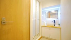 une salle de bains avec un lavabo et un miroir dans l'établissement Yuina Hotel Shinjuku, à Tokyo 23 autres photos