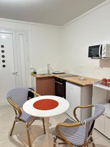 a kitchen with a white table and two chairs at Koli Fwi Studio in Pointe-Noire