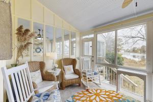a room with two chairs and a balcony with windows at Mallard Lakes --- 37816 Eagle Ln. # 322 in Selbyville