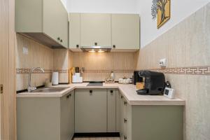 a kitchen with white cabinets and a sink at Central Luxury Apartments with Private Garden & Parking in Bucharest