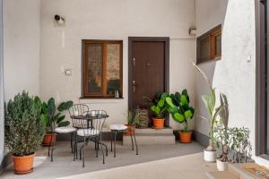 a patio with a table and chairs and plants at Central Luxury Apartments with Private Garden & Parking in Bucharest
