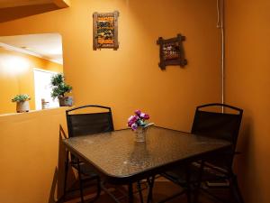 a dining room table with a vase of flowers on it at HOSTAL LA CASONA ALFREDO CAMPOS in Ovalle