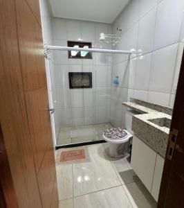 een badkamer met toilet en glazen douche bij Praia Grande House in Fundão