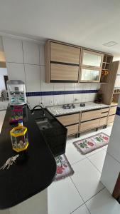 a kitchen with a black counter and some rugs at Águas cristalinas 02 in Cabo Frio +4 photos
