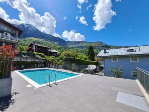 a swimming pool in a yard with mountains in the background at Agata House in Colico