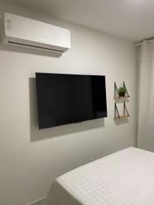 a flat screen tv hanging on a white wall at Apartamento de Alto Padrão Próximo à UFPE & Hospital Das Clínicas in Recife +23 photos