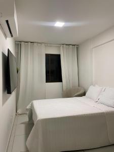 a white bedroom with a bed and a television at Apartamento de Alto Padrão Próximo à UFPE & Hospital Das Clínicas in Recife
