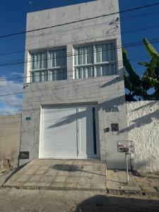 a building with a large white garage door at Casa moderna Malvinas in Campina Grande