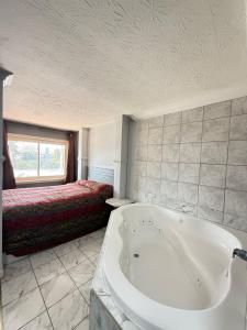 a bathroom with a bath tub and a bed at BlissPoint Inn FKA Motel 6t7 in Indianapolis +42 photos