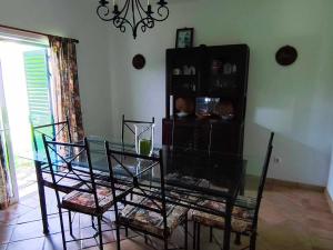 a dining room with a glass table and chairs at Albufeira INN - Mulatinho V3 in Olhos de Água