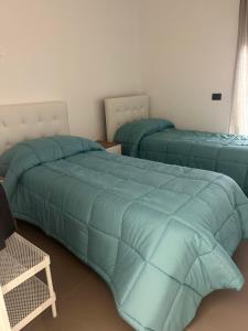 two beds in a bedroom with blue comforter at Salerno BellaVista in Salerno +14 photos