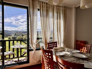 una sala da pranzo con un tavolo e una grande finestra di Duplex Golf El Mirador de Rovacías - Monabri a Comillas
