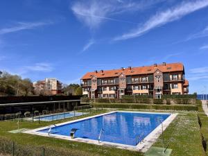 una grande casa con una piscina di fronte di Duplex Golf El Mirador de Rovacías - Monabri a Comillas