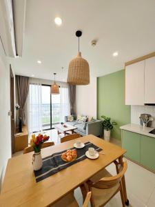 Gò CôngにあるNhat Ha Friendly Group Homestayの木製のテーブルのあるキッチンとリビングルーム