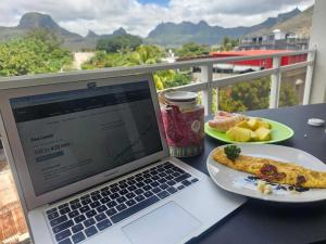 路易港Mountain View Haven, Port Louis的坐在桌子上的一台笔记本电脑,上面放着一盘食物 更多10张照片