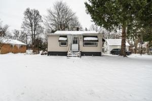 a house in a yard with snow on the ground at Beachwood Area in Woodmere